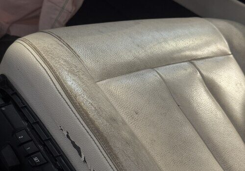Worn white leather car seat showing creases and discoloration – Leather Seat Restoration in San Diego