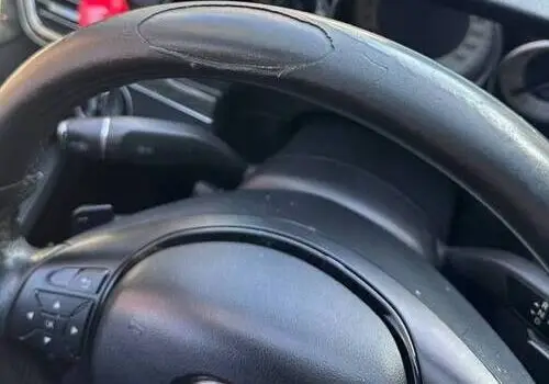 Worn black leather steering wheel interior showing cracks and peeling — Steering Wheel Repair in San Diego