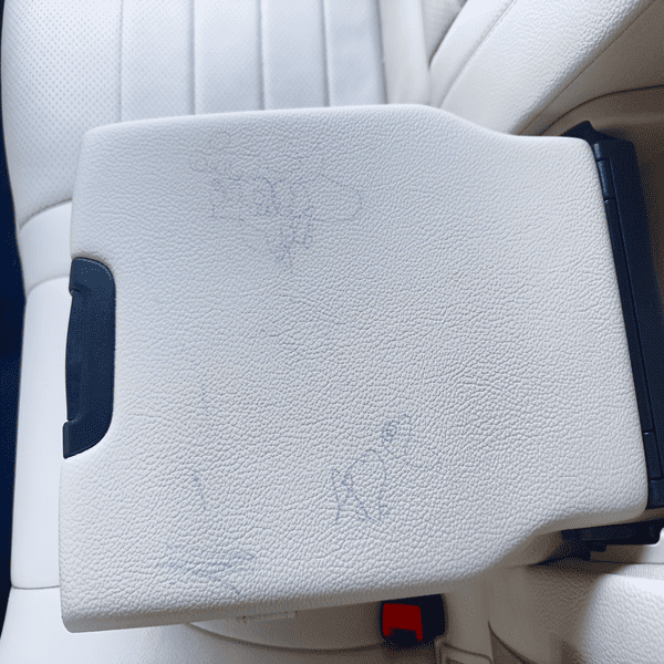Leather car armrest with drawings before professional leather color restoration in San Diego