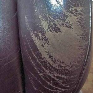 Faded and scuffed leather seat bolster before restoration
