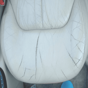 Worn and cracked leather car seat before restoration