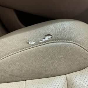 Peeling beige leather car seat before repair