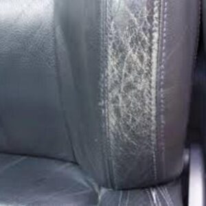 Worn and cracked leather seat bolster before repair