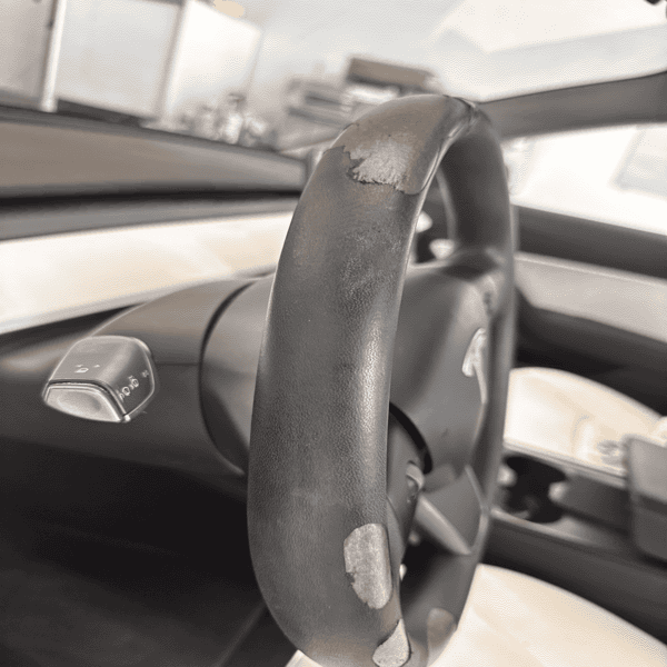 Tesla steering wheel before restoration – peeling polyurethane coating Title: Tesla Steering Wheel Before Restoration 2