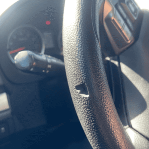 Leather steering wheel with a hole and surface damage before restoration