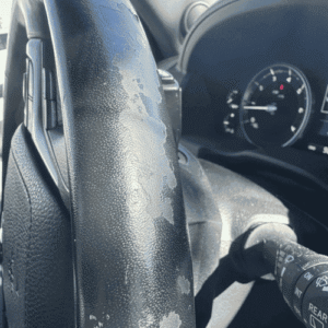 Leather steering wheel with peeling and fading before restoration