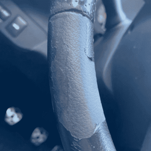 Leather steering wheel with severe peeling and damage before restoration