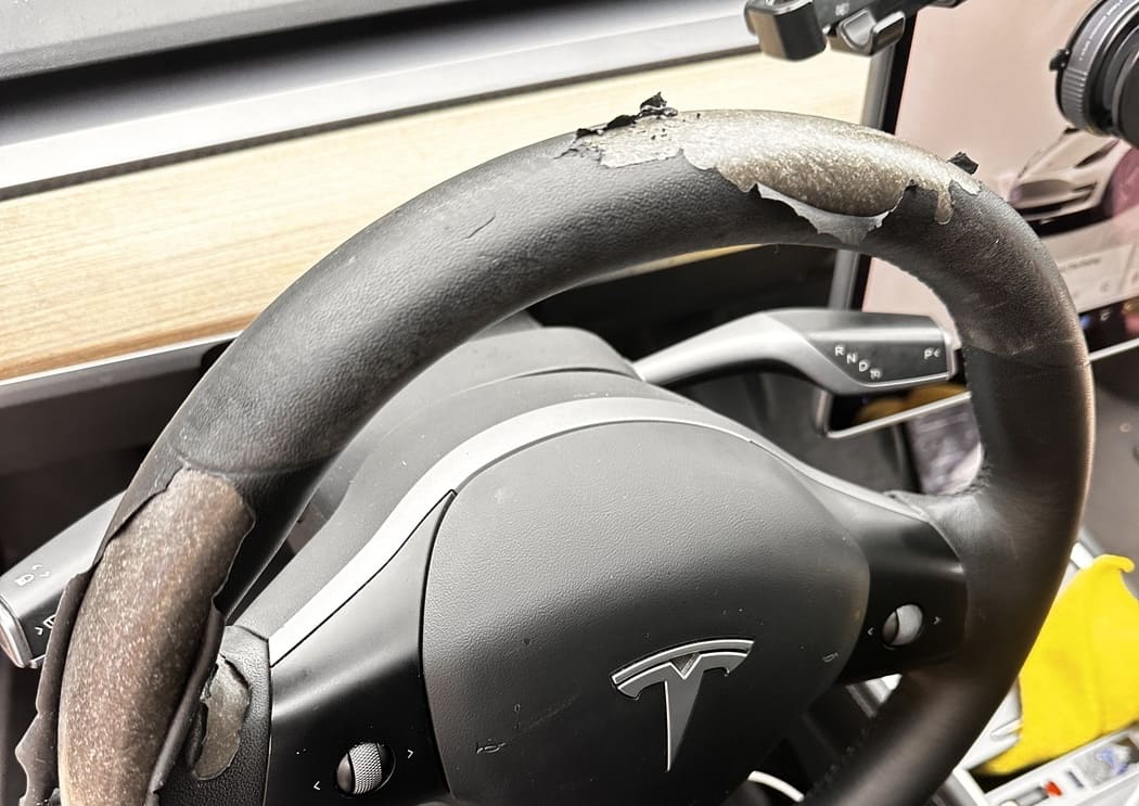 Tesla steering wheel uphortery before restoration with peeling and worn leather