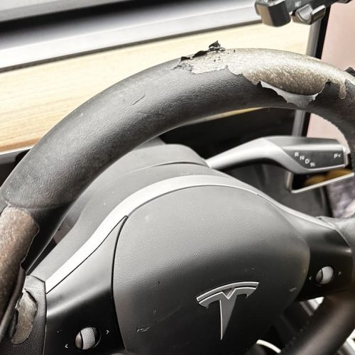 Tesla steering wheel uphortery before restoration with peeling and worn leather