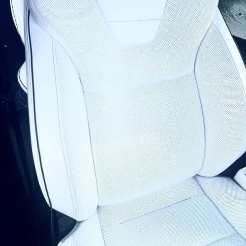 Restored white Tesla seat after professional interior leather repair in San Diego